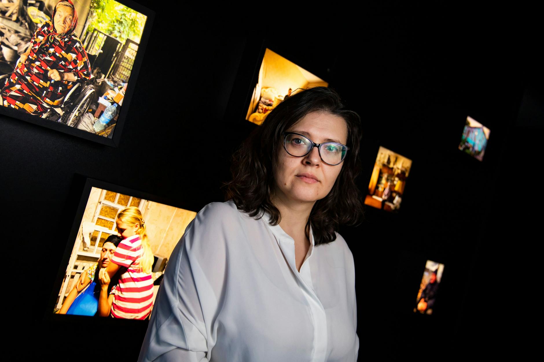 Kateryna Leontyeva posiert vor einer Ausstellung im Berliner Pilecki-Institut. Die Ausstellung zeigt Beweisfotos, die das Lemkin-Zentrum für die Dokumentation von russischer Kriegsverbrechen von Zeugen aus der Ukraine gesammelt hat.