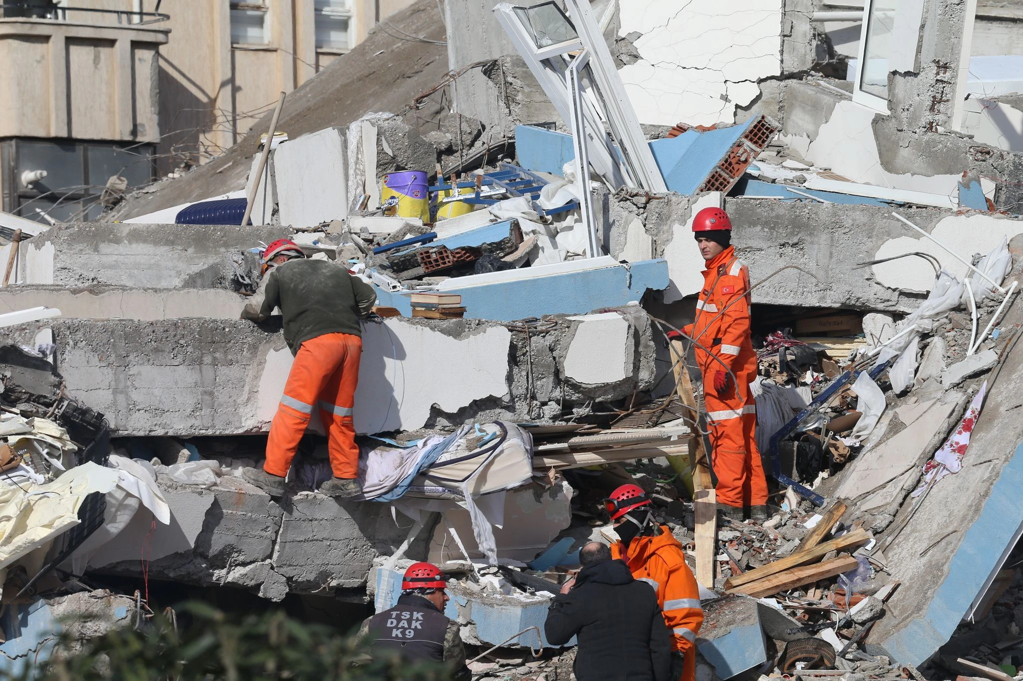 Rettungskräfte suchen in Kahramanmaras in den Trümmern eines Gebäudes nach Überlebenden.  