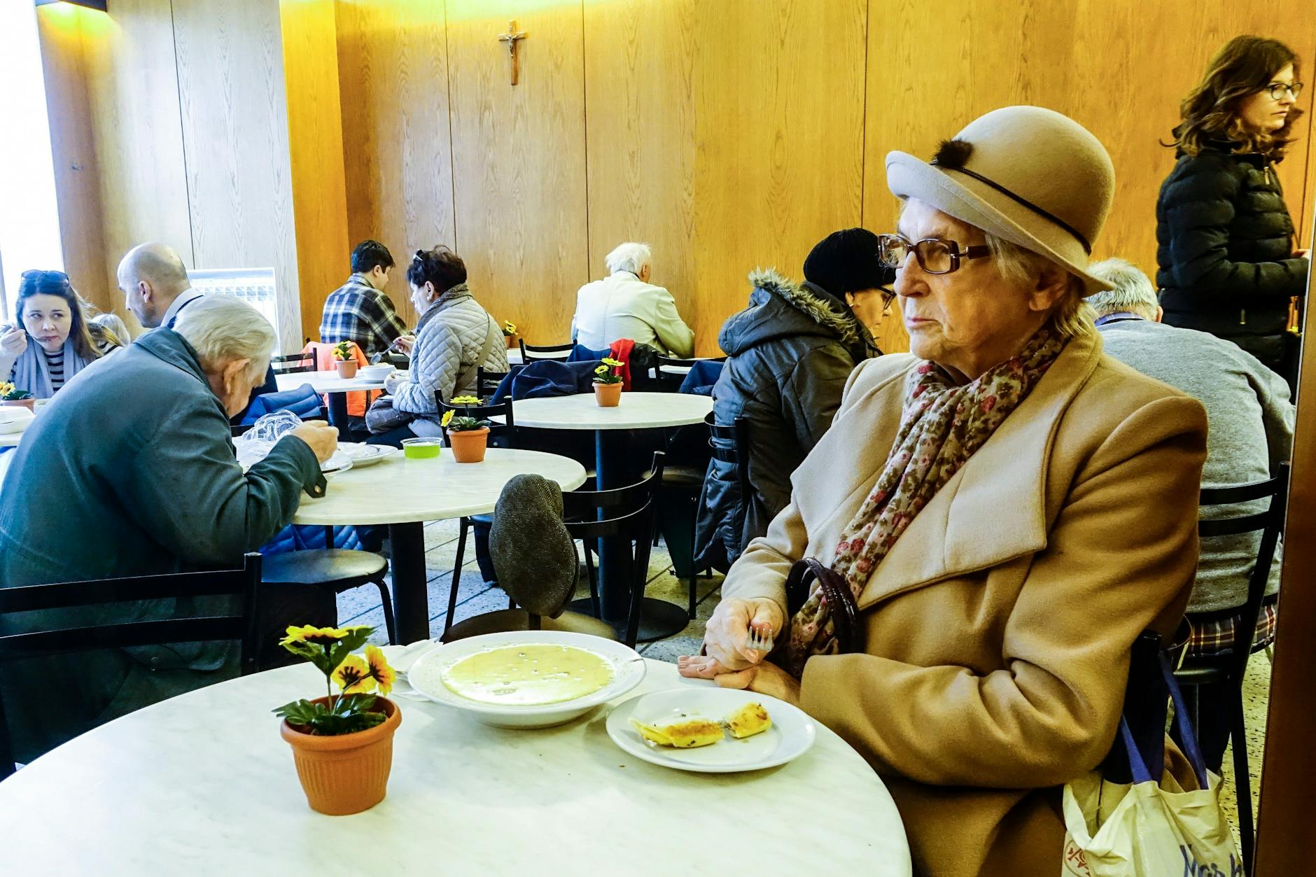 Eine ältere Dame sitzt in einer polnischen Milchbar, einem traditionellen, niedrigpreisigen Restaurant in Warschau. 