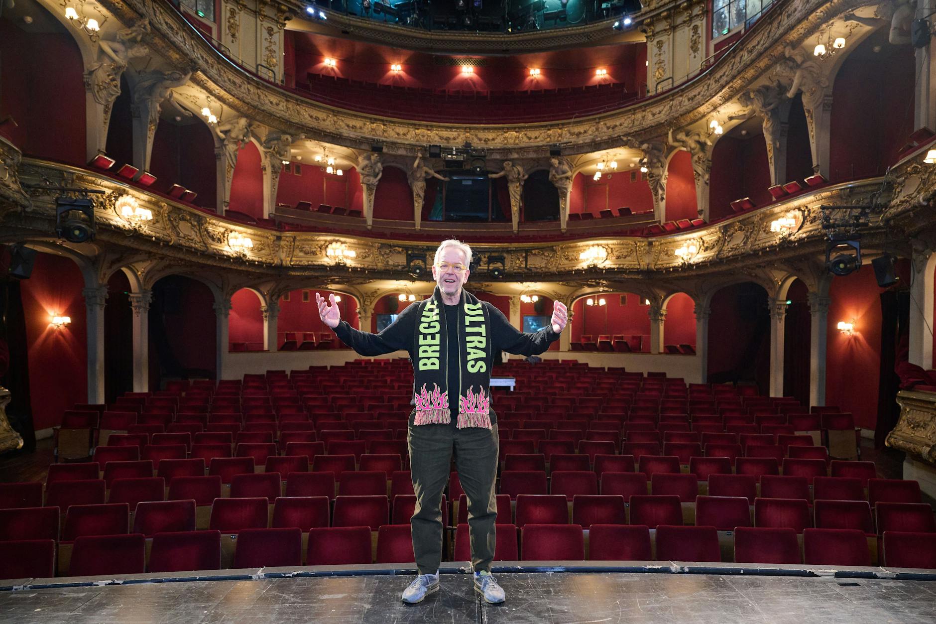 Oliver Reese, Intendant des Berliner Ensembles, steht im Berliner Ensemble mit einem Schal auf dem „Brecht Ultras“ steht.