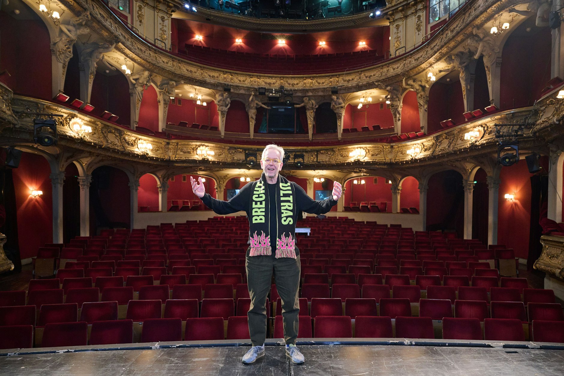 Oliver Reese, Intendant des Berliner Ensembles, steht im Berliner Ensemble mit einem Schal auf dem „Brecht Ultras“ steht.