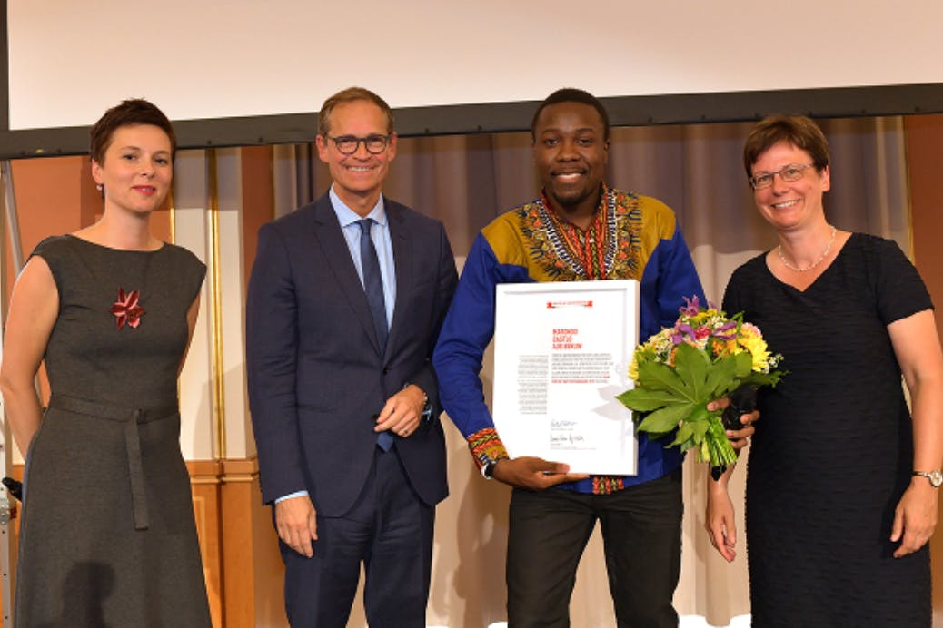 Michael Müller (2.v.l.) überreicht Matondo Castlo (2.v.r.) das Band für Mut und Verständigung in Berlin.