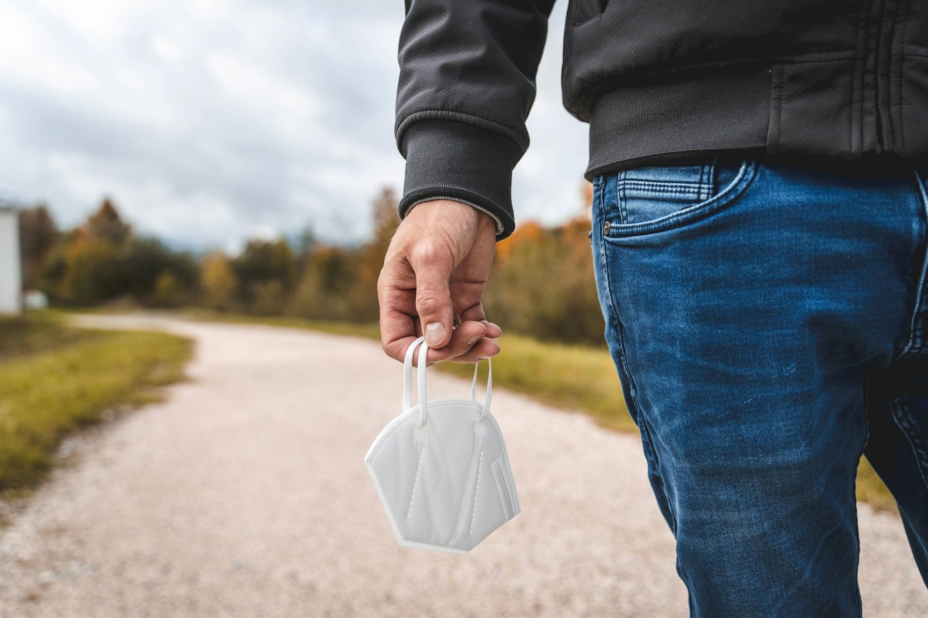 Mann hält Maske in der Hand.