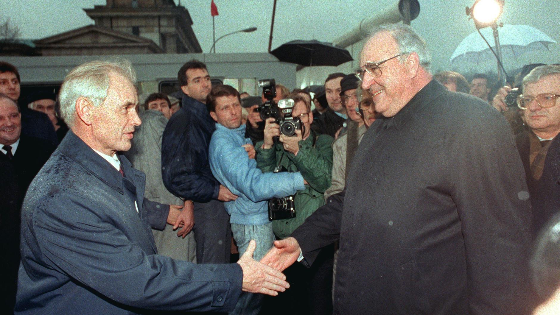 Der Ministerpräsident der DDR, Hans Modrow (l.), empfängt Bundeskanzler Helmut Kohl (CDU) am 22. Dezember 1989 auf der Ostseite des Brandenburger Tores.