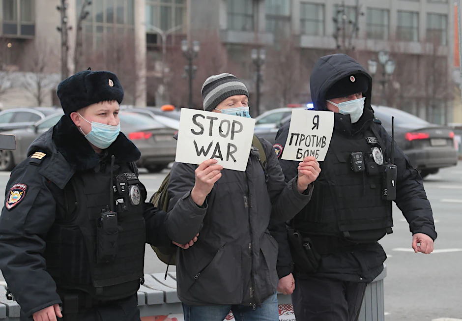 In Moskau wird ein Demonstrant von Polizisten abgeführt.