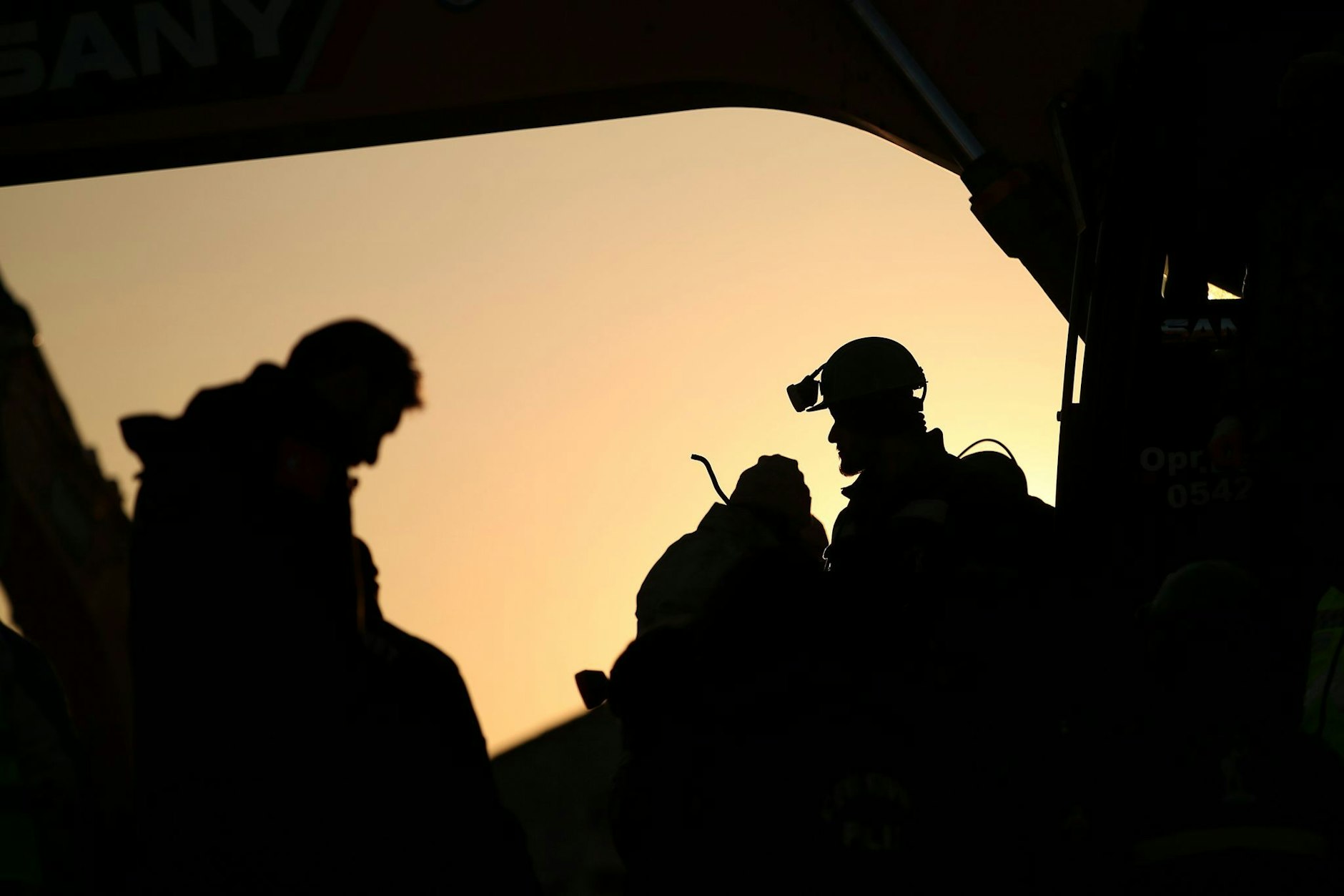 Türkische Rettungskräfte stehen an einem eingestürzten Gebäude.