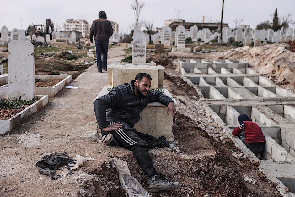 In Idlib heben Syrer entlang der türkisch-syrischen Grenze Gräber für ihre Angehörigen aus, die bei dem verheerenden Erdbeben ums Leben gekommen sind.