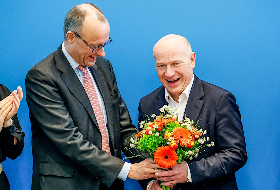 Friedrich Merz (l), CDU-Bundesvorsitzender, überreicht Kai Wegner (CDU) einen Blumenstrauß.  