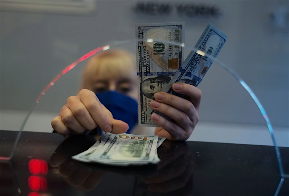 Eine Frau zählt Dollar-Noten in einer Bank (Symbolbild).&nbsp;