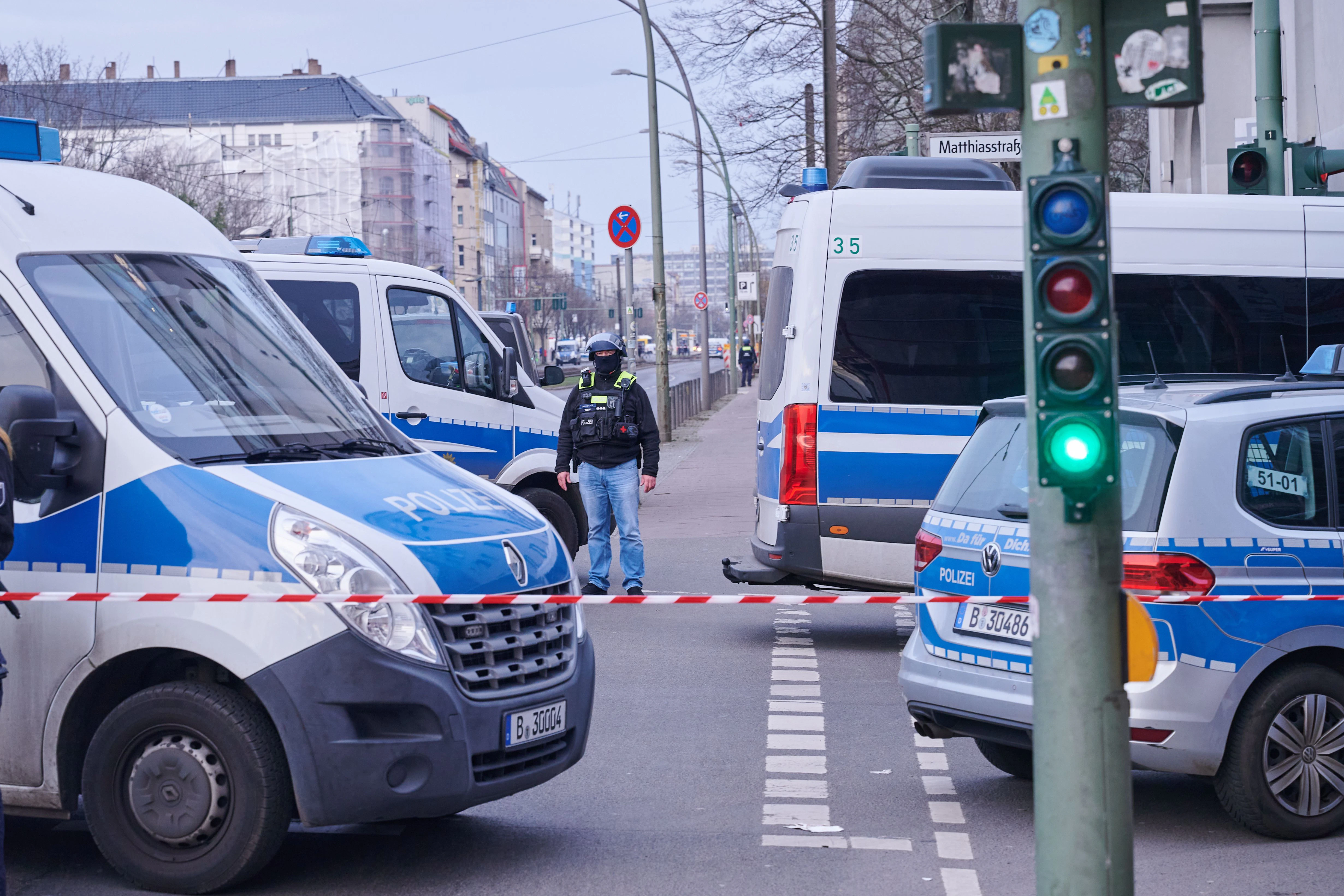 Einsatzfahrzeuge hinter der Absperrung an der Landsberger Allee. Einsatzkräfte befinden sich im Gebäude.&nbsp;