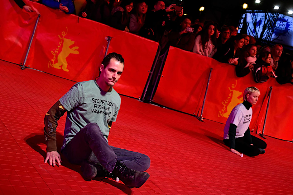Mitglieder der Letzten Generation kleben auf dem roten Teppich bei der Berlinale.