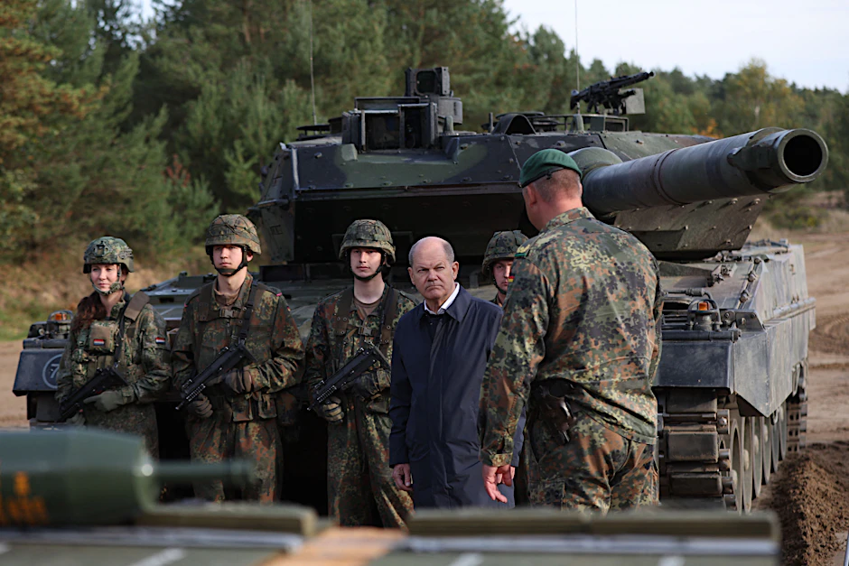 Bundeskanzler Olaf Scholz im Gespräch mit Soldaten vor einem Leopard-2-Kampfpanzer der Bundeswehr.