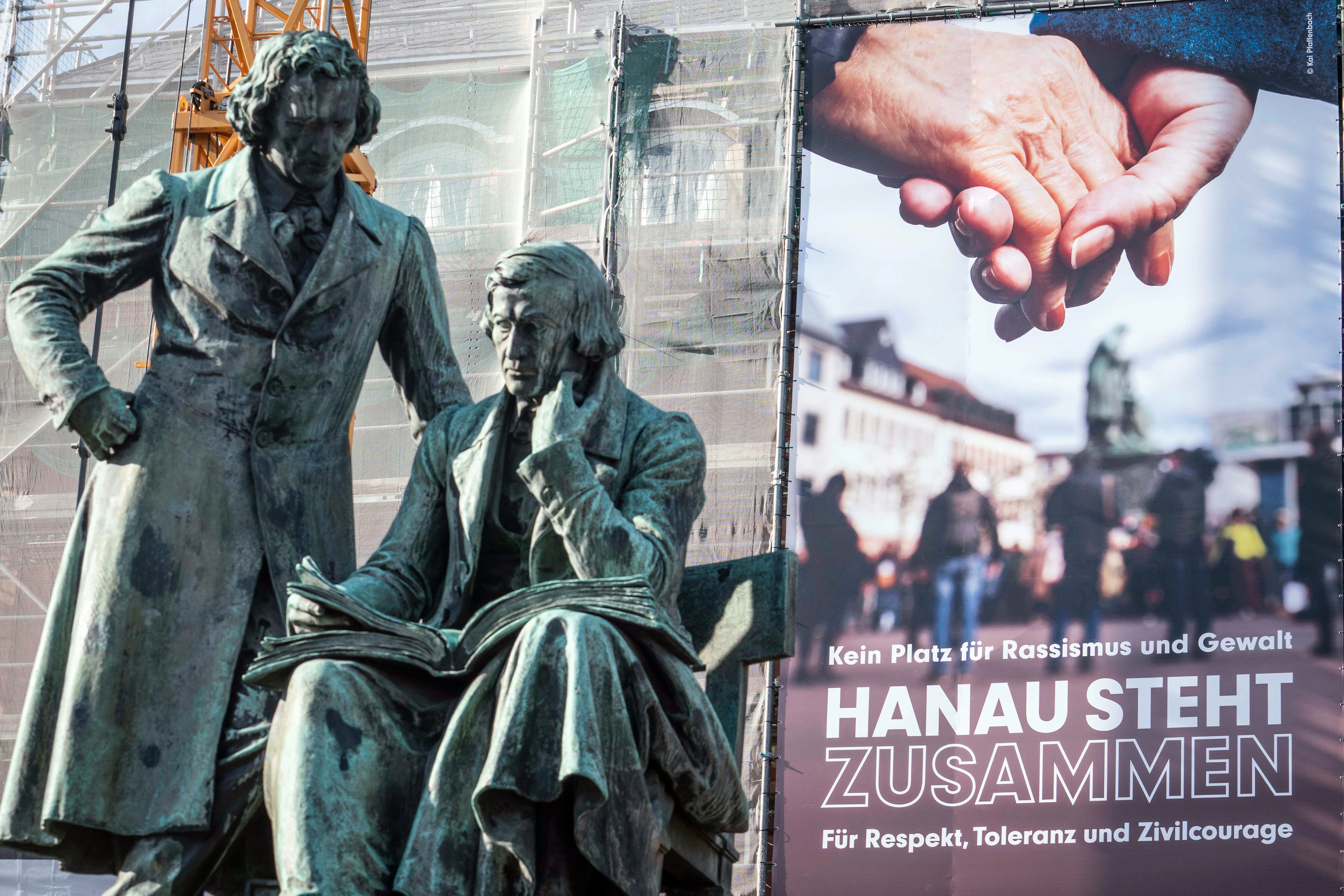 „Kein Platz für Rassismus und Gewalt – Hanau steht zusammen für Respekt, Toleranz und Zivilcourage“ hängt an der Fassade des Rathauses hinter dem Gebrüder-Grimm-Denkmal.