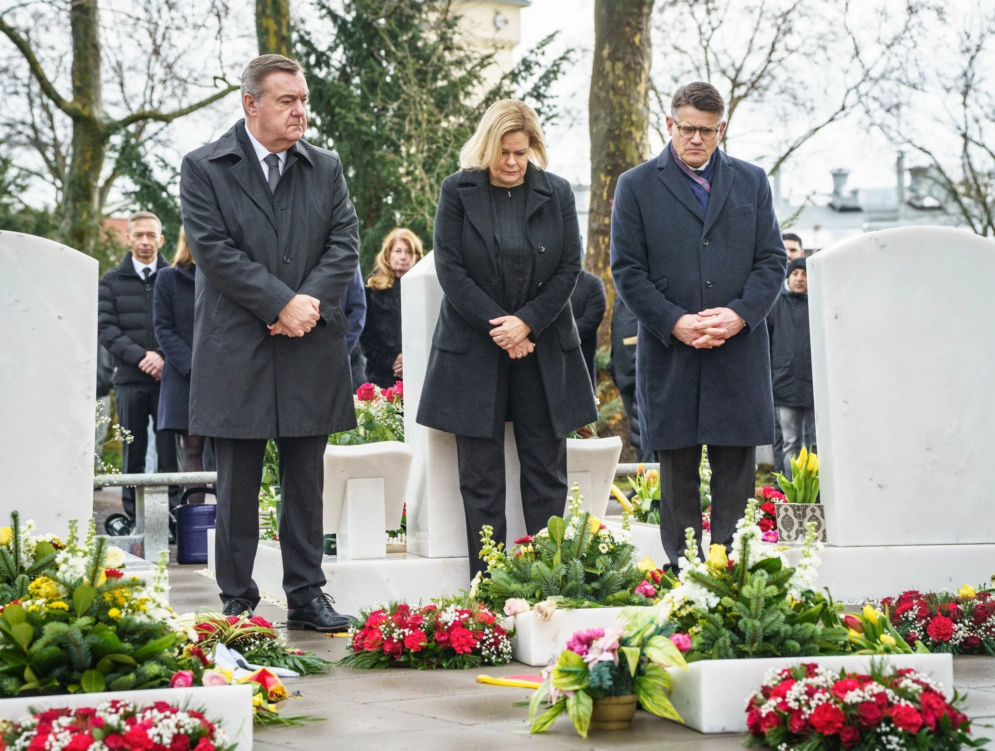 Hanaus Oberbürgermeister Claus Kaminsky (v.l.), Bundesinnenministerin Nancy Faeser und Hessens Ministerpräsident Boris Rhein gedenken auf dem Hanauer Hauptfriedhof der Anschlagsopfer.  