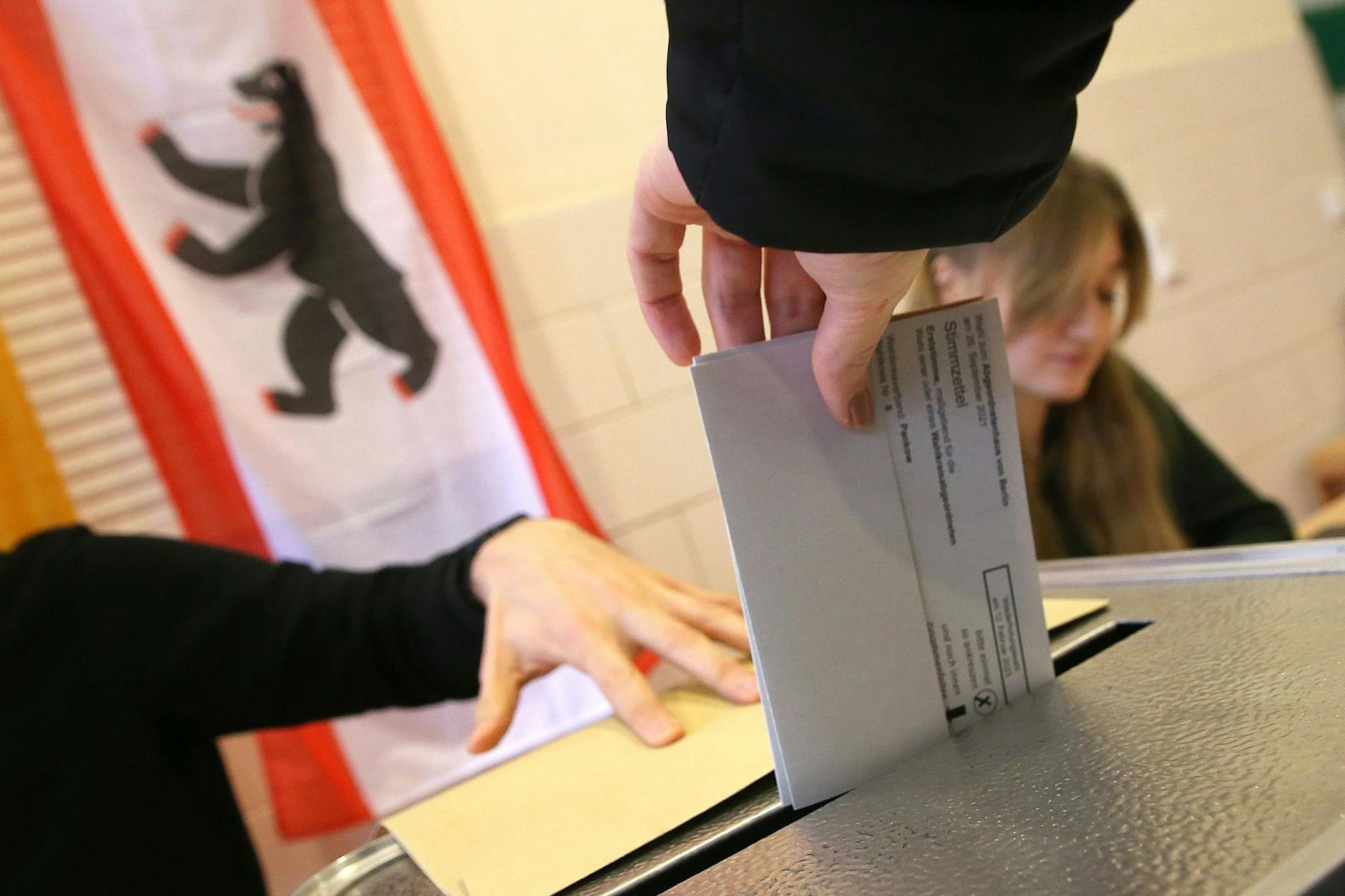 Eine Frau gibt ihre Stimme für die Wahl zum Berliner Abgeordnetenhaus ab und wirft ihren Wahlzettel in die Wahlurne.