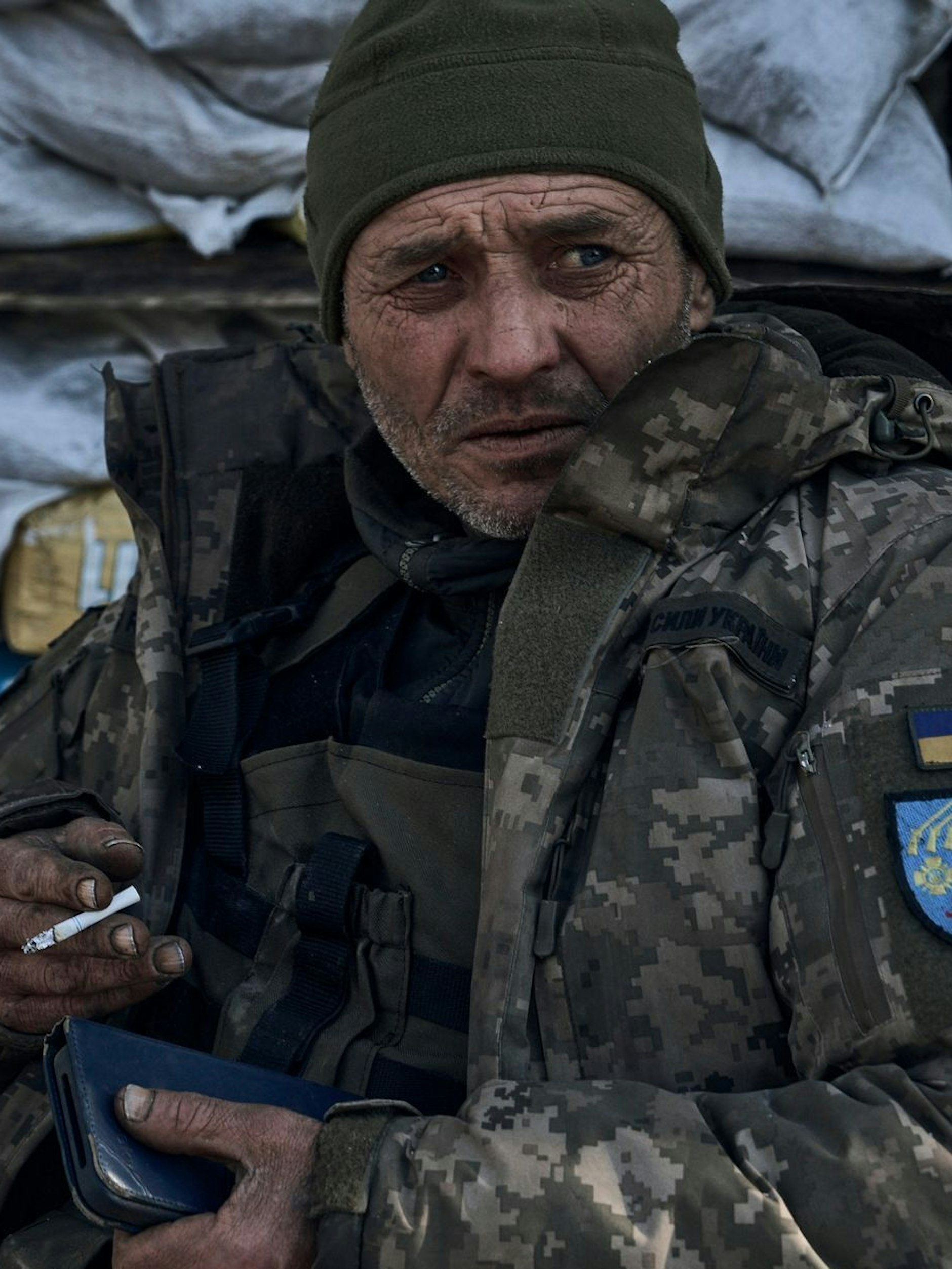 Ein erschöpfter ukrainischer Soldat der Truppe, die die Stadt Bachmut verteidigt, raucht eine Zigarette.