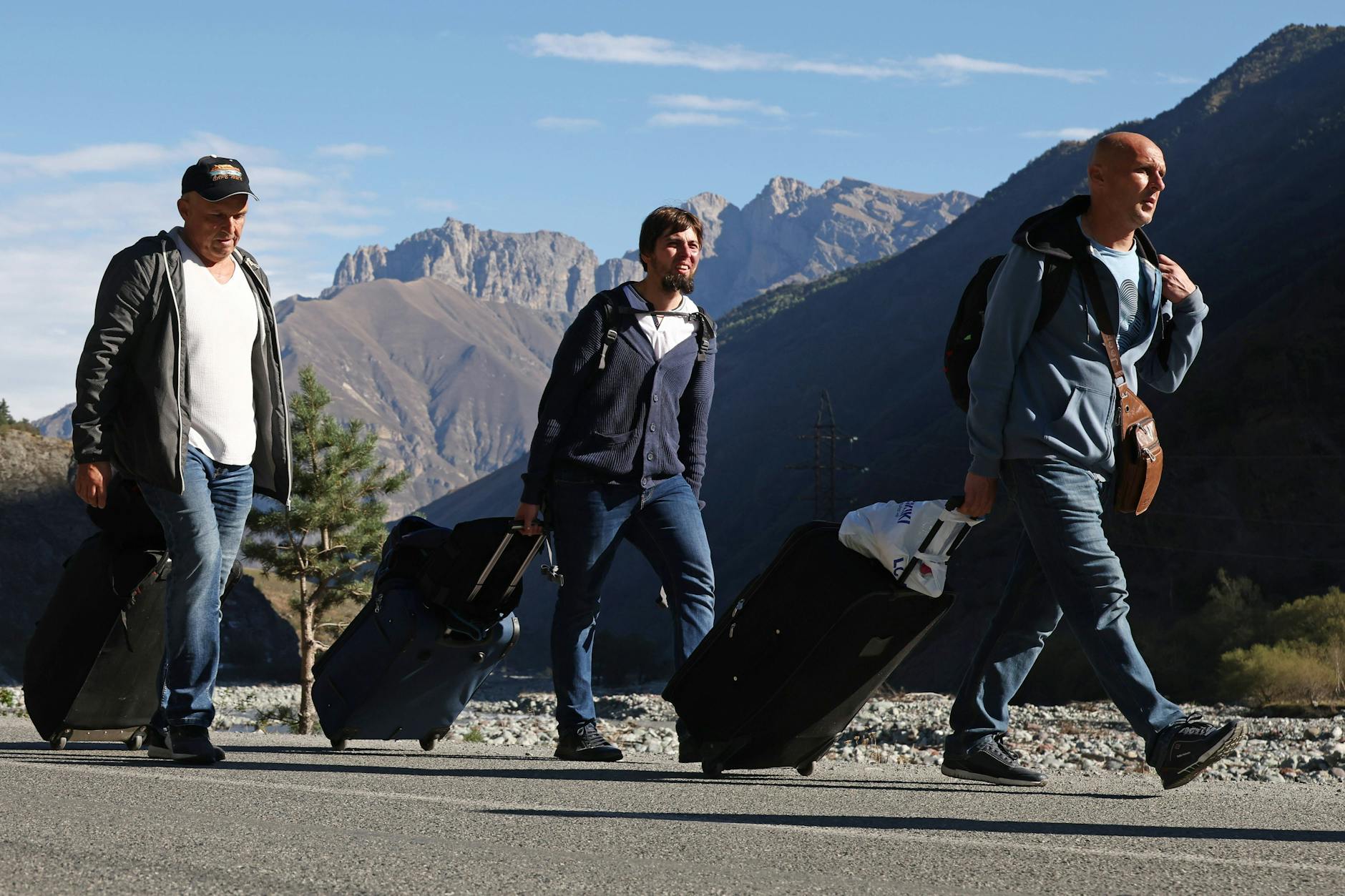 Russische Bürger laufen zu Fuß zur georgischen Grenze.