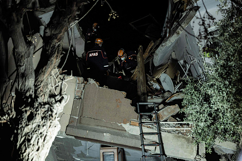 Hatay: Helfer suchen in einem zerstörten Haus nach Opfern.