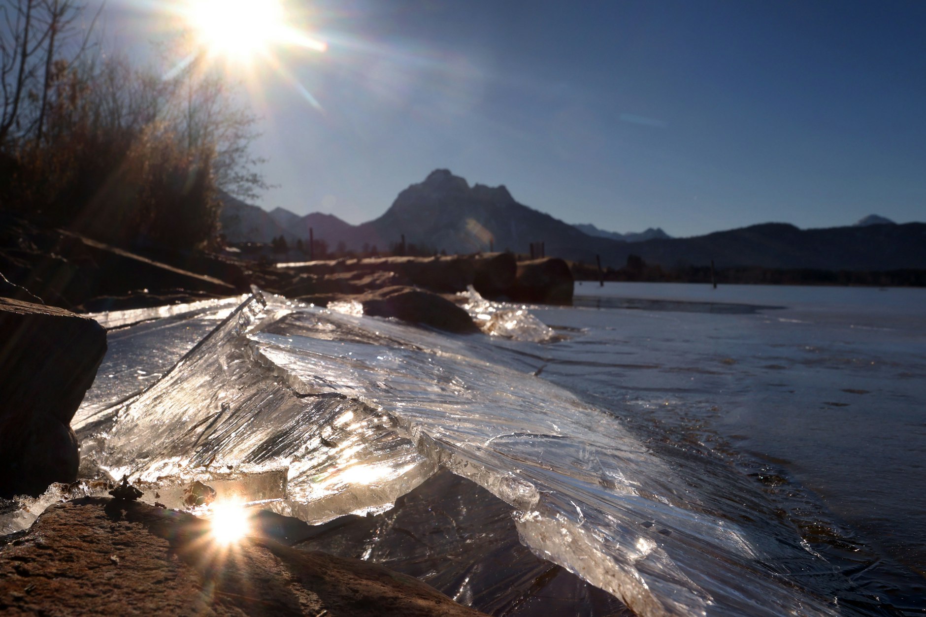 Eis taut am Ufer des am Alpenrand gelegenen Hopfensees im Sonnenschein. Doch laut Wetter-Prognosen könnte es noch mal richtig kalt werden.