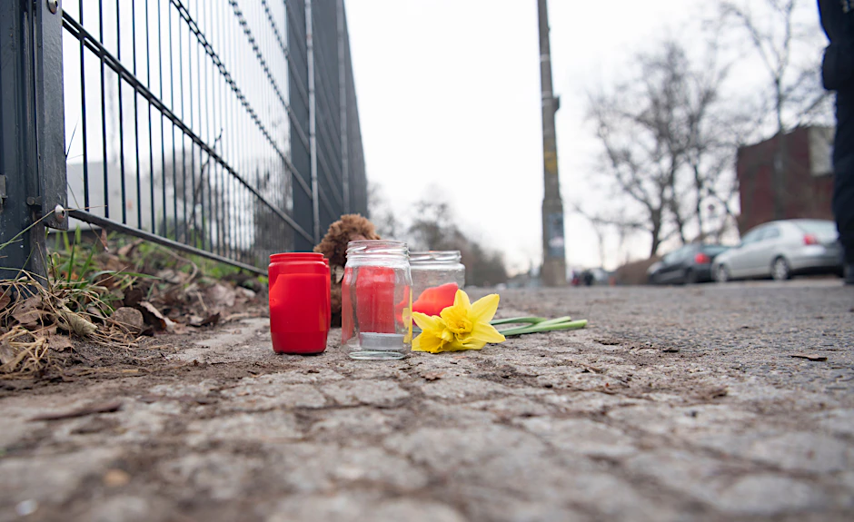 Kerzen und Blumen stehen unweit der Stelle, an der das schwer verletzte Kind gefunden wurde.