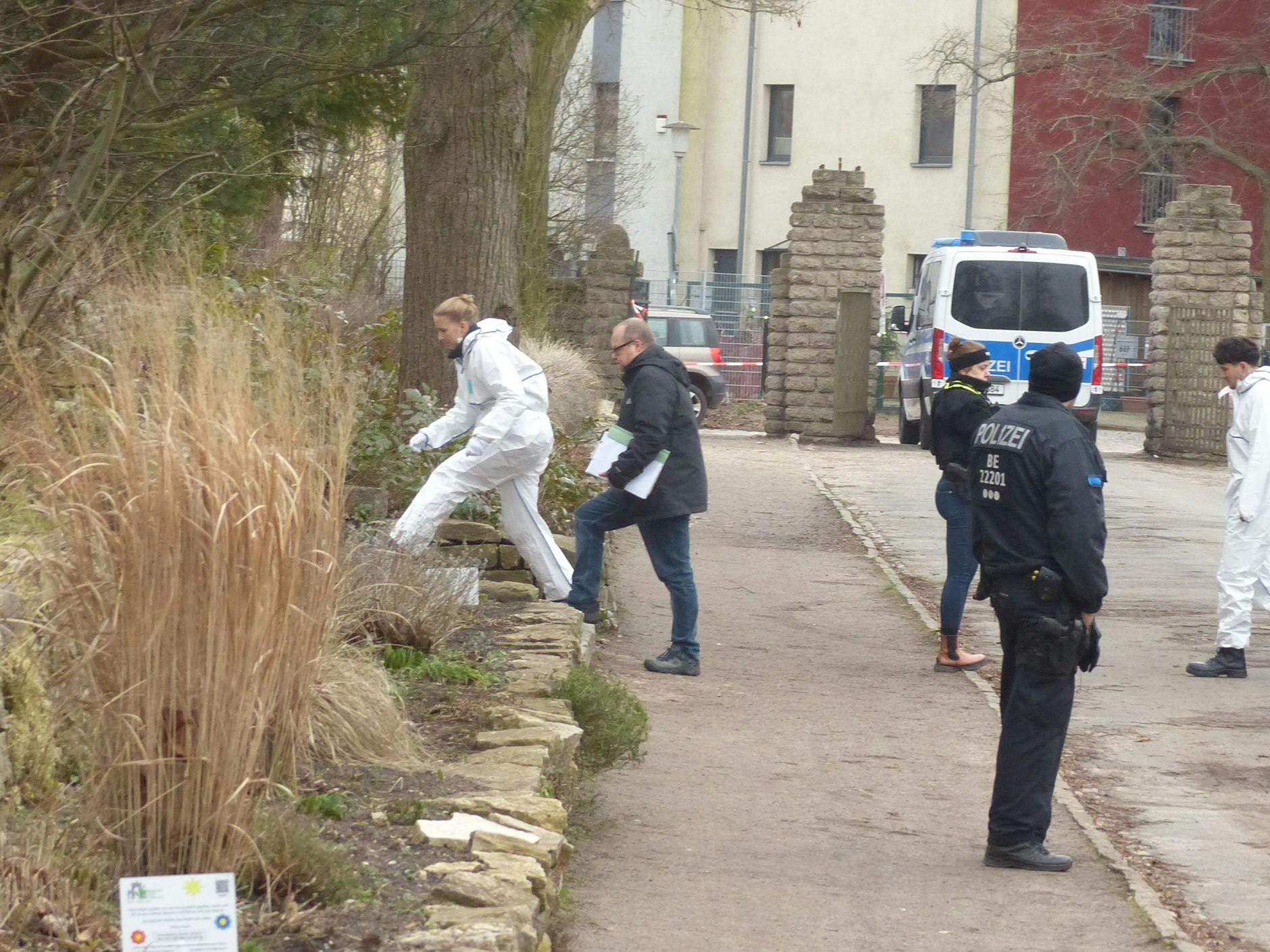 Eine Kriminaltechnikerin und ein Kripo-Kollege am frühen Mittwoch Nachmittag auf dem Weg auf den Hügel an der Wilhelm-Kuhr-Straße, auf dem das schwer verletzte Mädchen am Dienstag gefunden worden war.