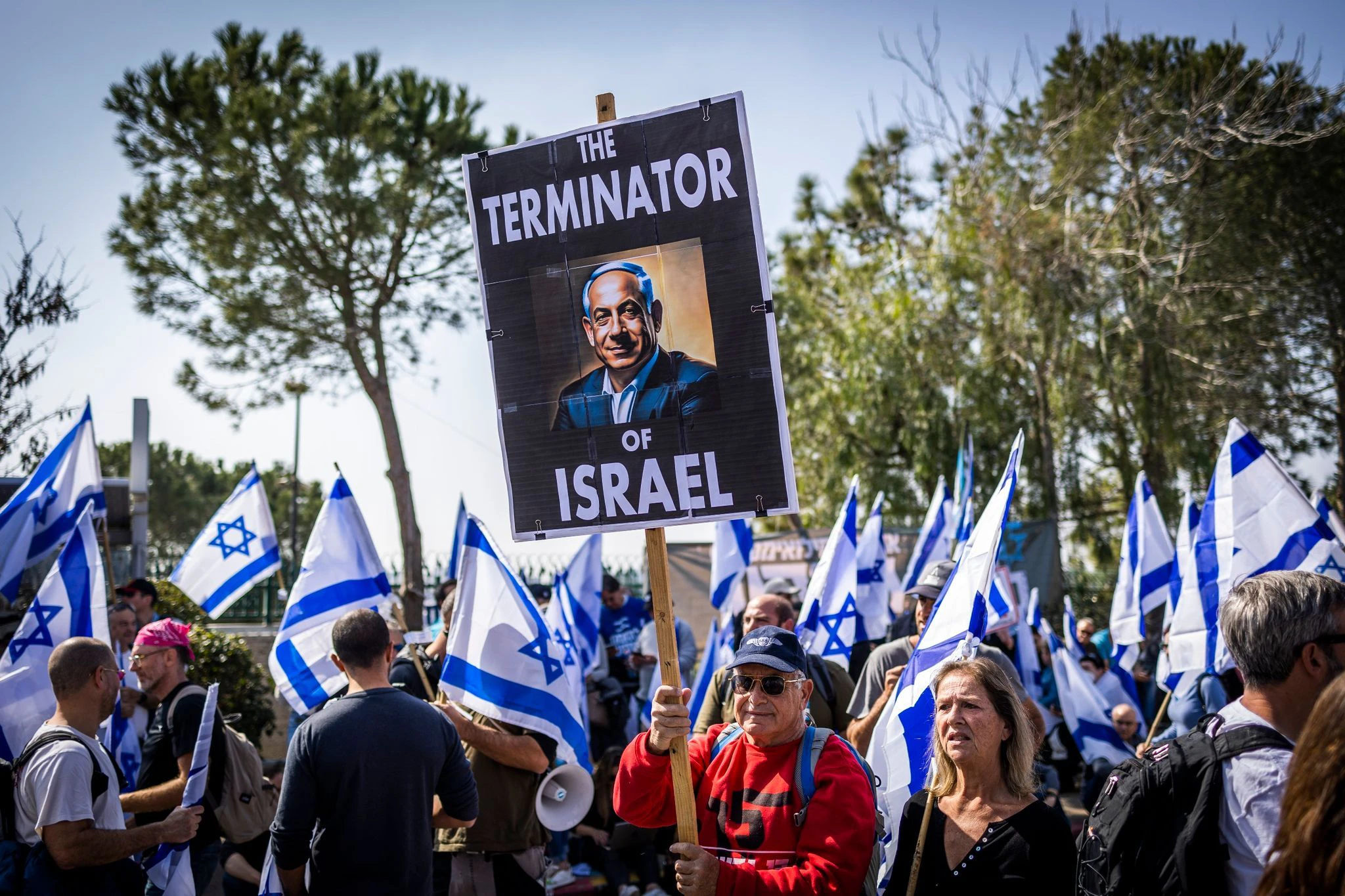 Israelische Demonstranten halten Fahnen und Schilder während eines Protestes gegen die Justizreformen vor der Knesset.  