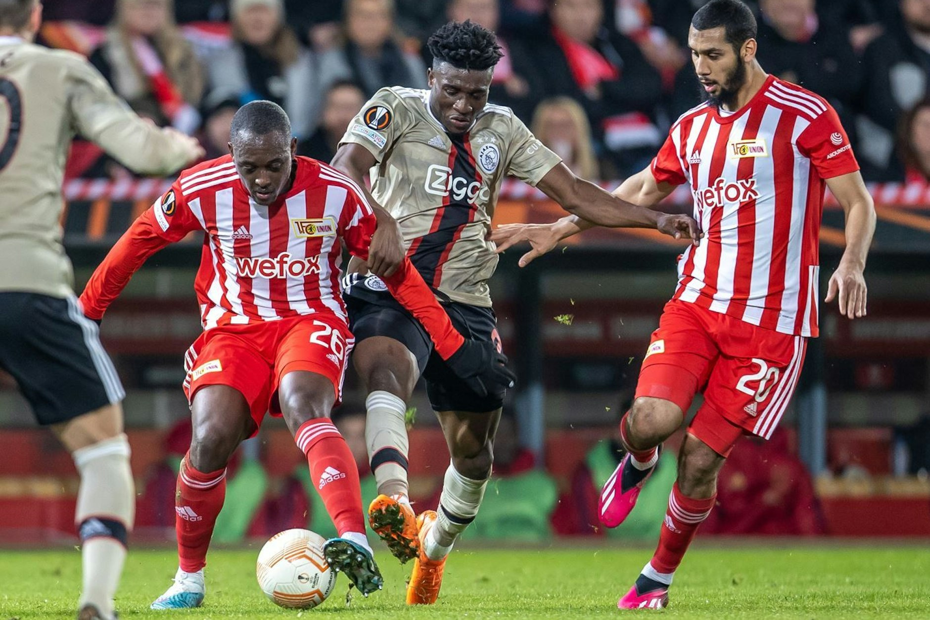 Berlins Jerome Roussillon (l.) und Aissa Laidouni (r.) kämpfen gegen Mohammed Kudus von Ajax Amsterdam um den Ball.