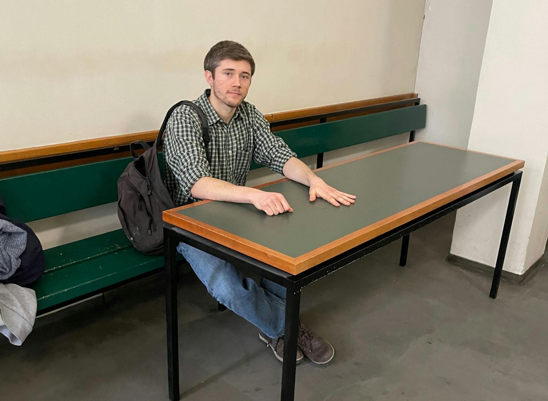 Klimaaktivist Henning Jeschke sitzt festgeklebt an einem Tisch in einem Raum des Amtsgericht Tiergarten.