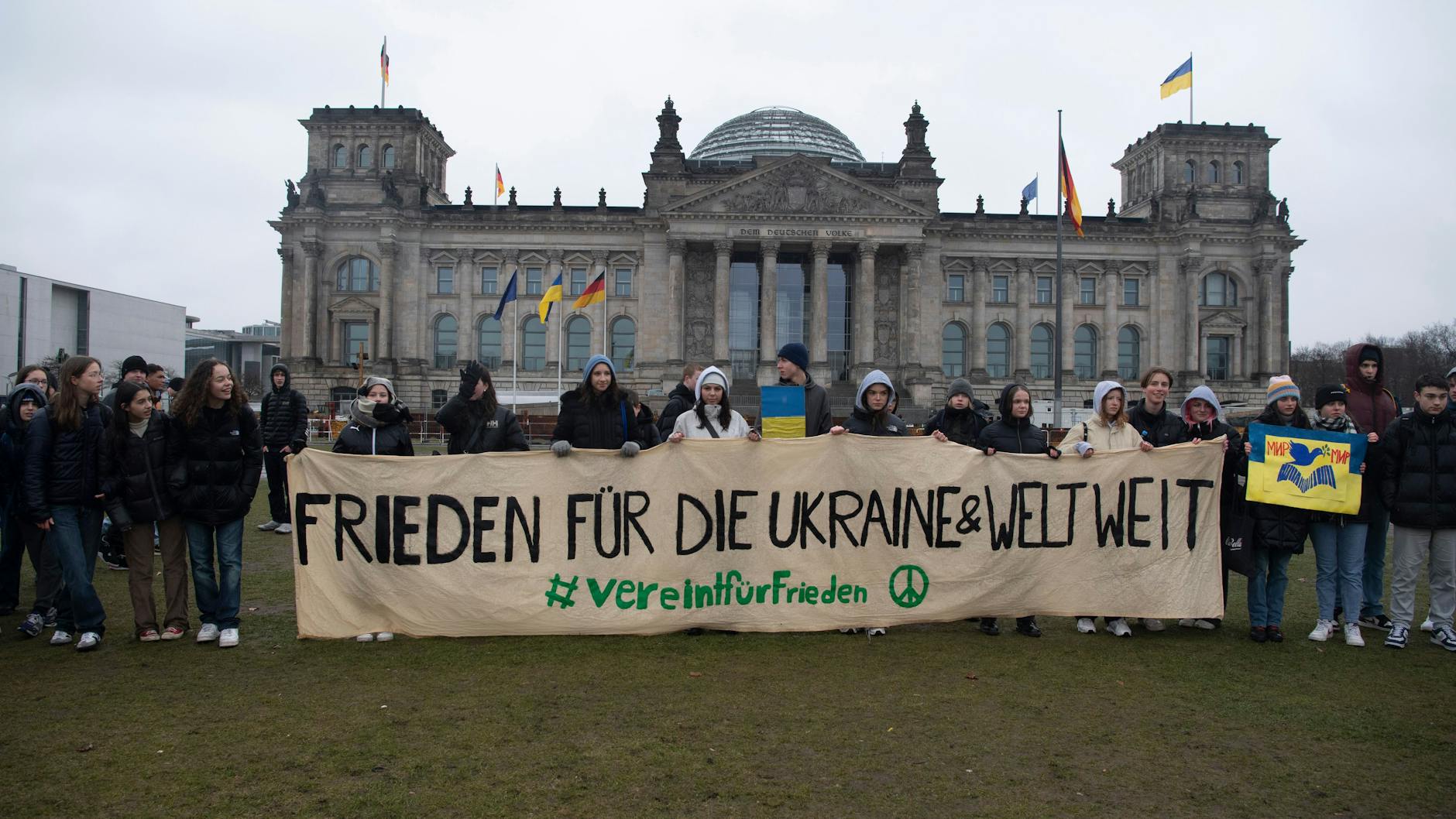 Schüler aus Berlin nehmen vor dem Reichstag an einer Demonstration gegen den russischen Angriffskrieg in der Ukraine am Jahrestag des Kriegsbeginns teil. 