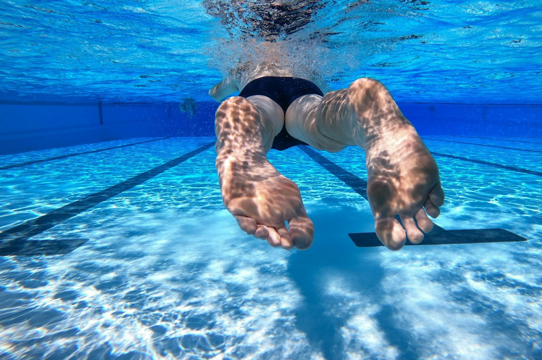 ARCHIV - Ein Schwimmer schwimmt durch ein Becken im Freibad.  