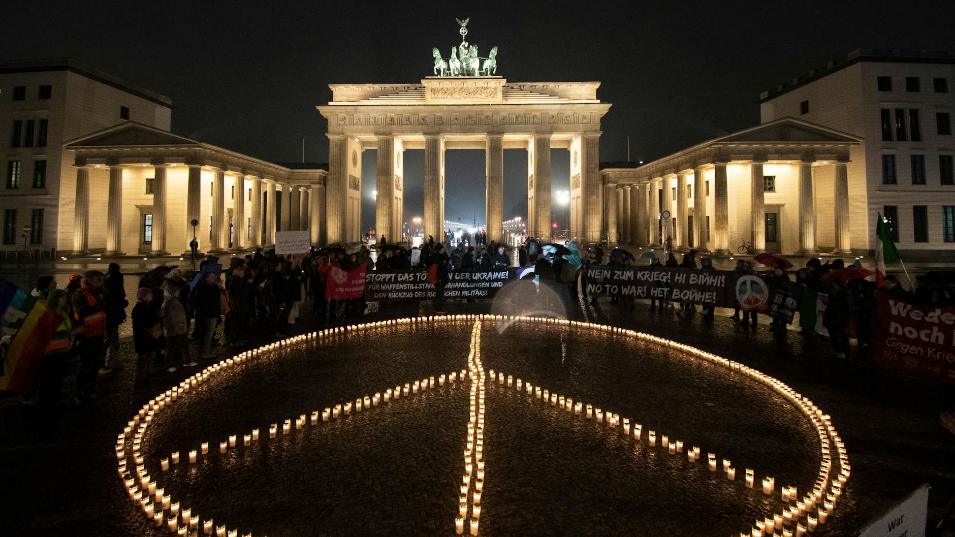 Am Vorabend des Jahrestages des russischen Angriffskriegs auf die Ukraine haben Aktivisten ein übergroßes Peace-Zeichen aus Kerzen vor das Brandenburger Tor gestellt. 