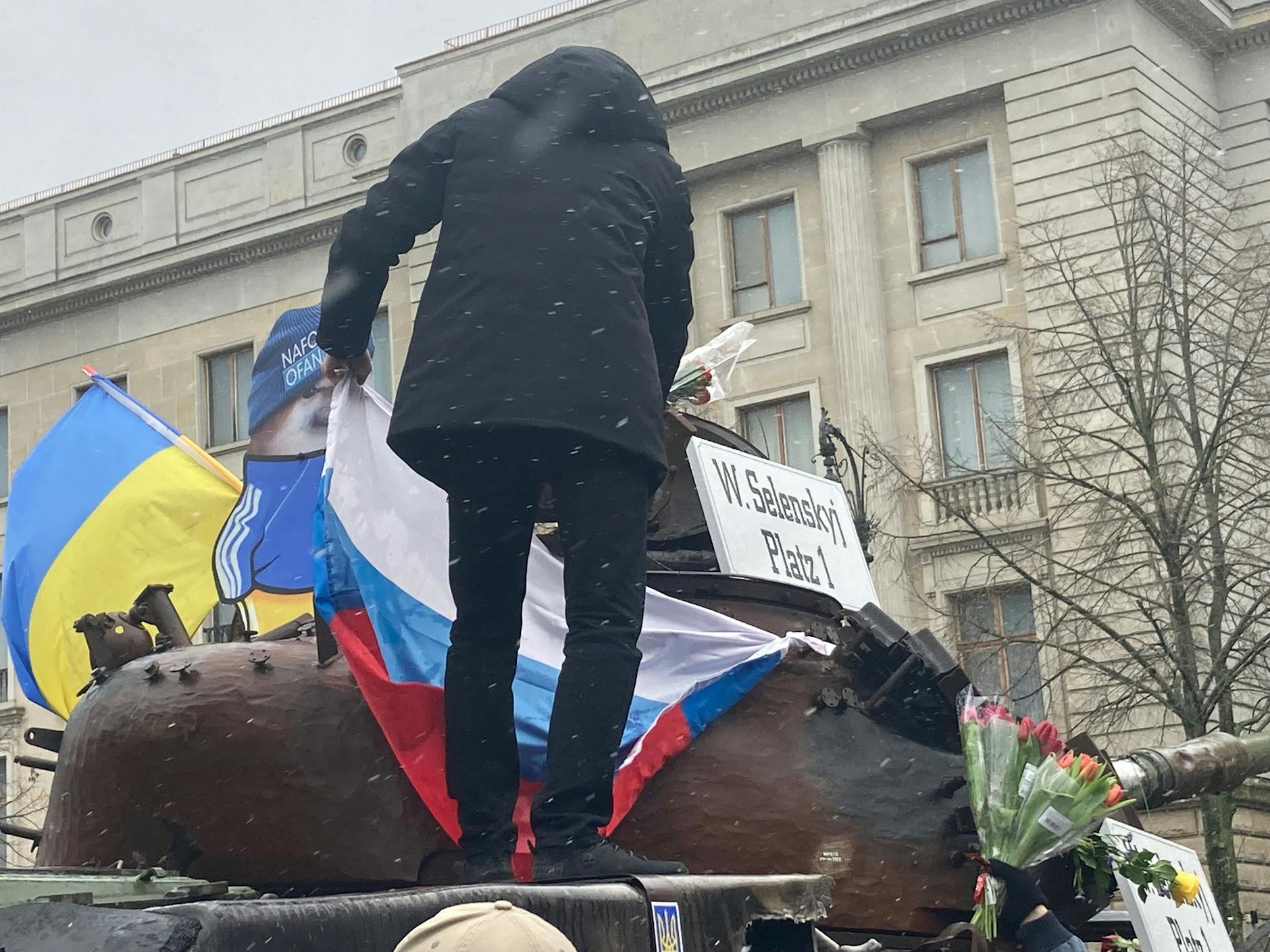 Währenddessen versuchte ein Mann, auf das am Freitagmorgen als Protest aufgestellte Panzerwrack vor der russischen Botschaft eine Russlandfahne auf den vor der russischen Botschaft abgestellten Panzer anzubringen.