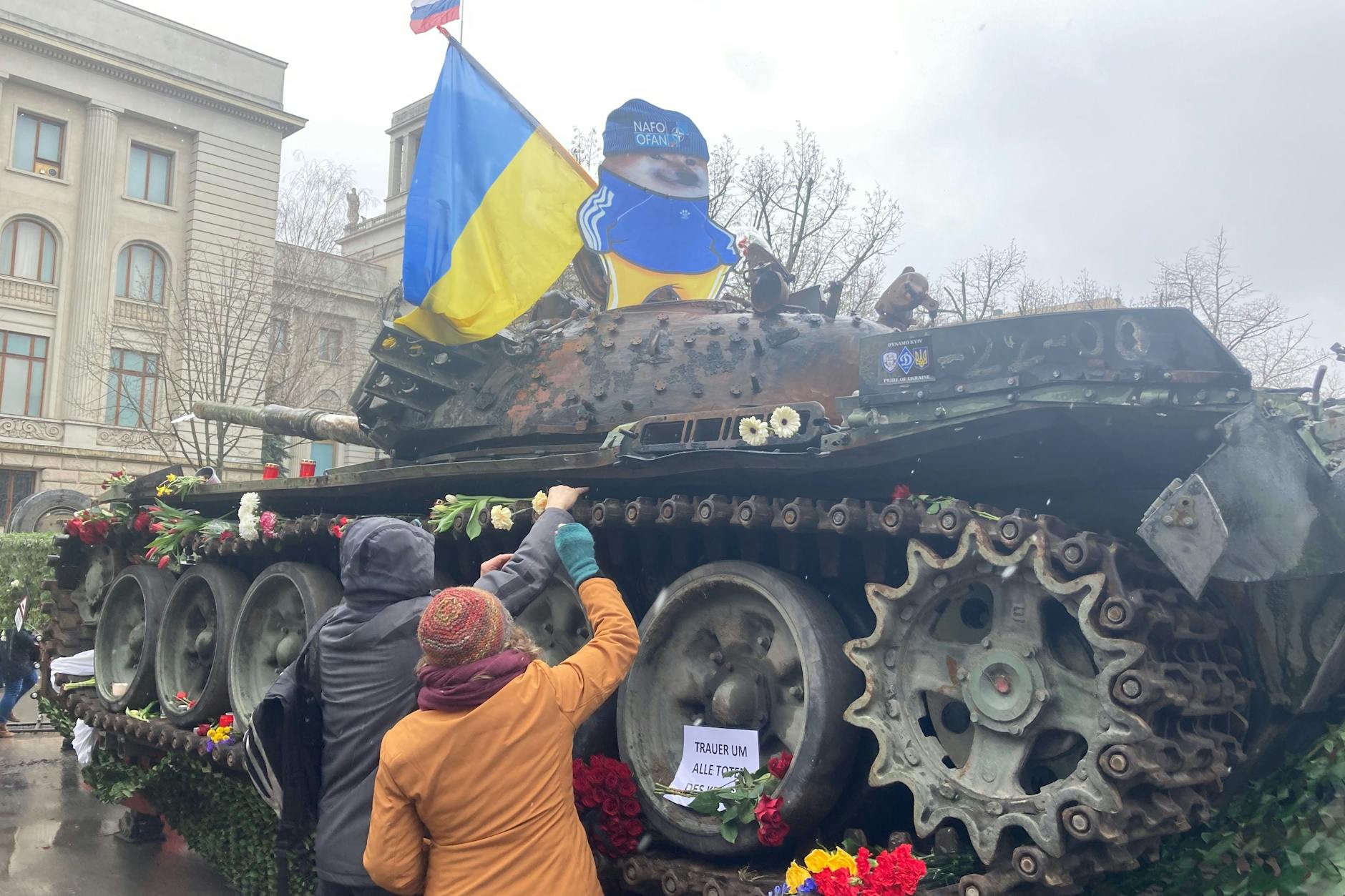 Ein Panzer als Zeichen des Protests vor der russischen Botschaft in Berlin. Demonstranten legen Blumen ab.