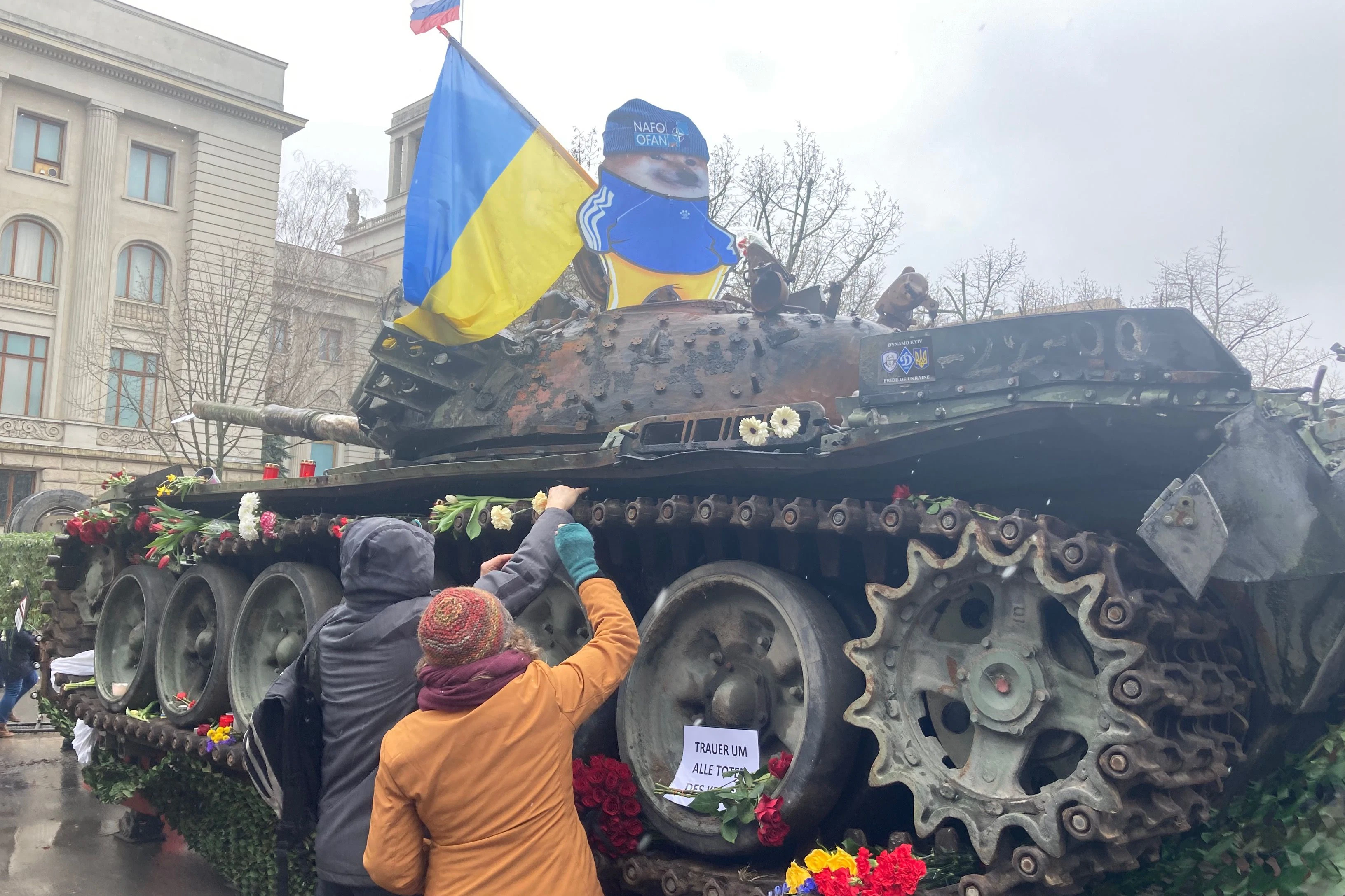 Ein Panzer als Zeichen des Protests vor der russischen Botschaft in Berlin. Demonstranten legen Blumen ab.