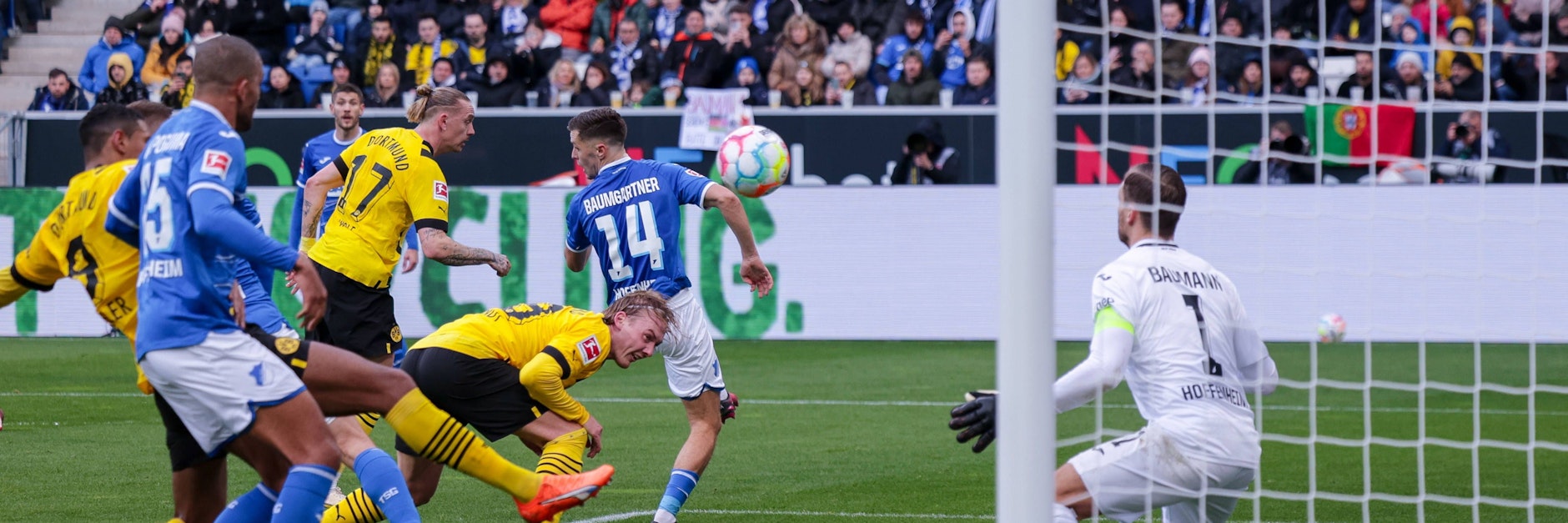 Mit dem Rücken zwirbelt Dortmunds Julian Brandt die Kugel an Hoffenheims Keeper Oliver Baumann vorbei zum 1:0 für die Borussia.