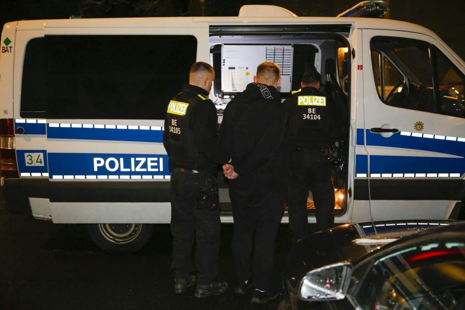 Die Polizei nimmt einen Verdächtigen fest.