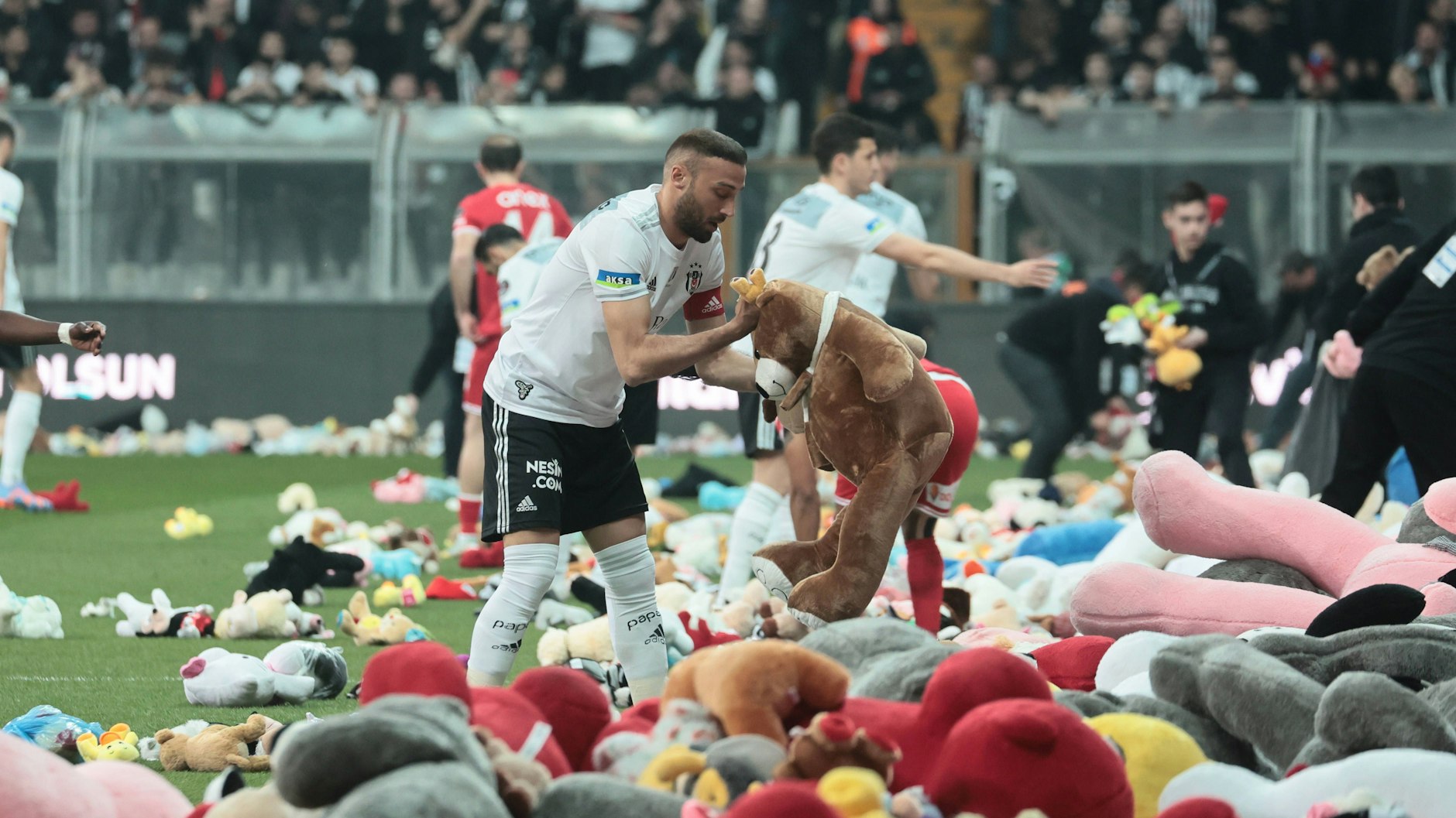 Spieler von Besiktas und Antalyaspor räumen die Spielzeuge vom Feld. 