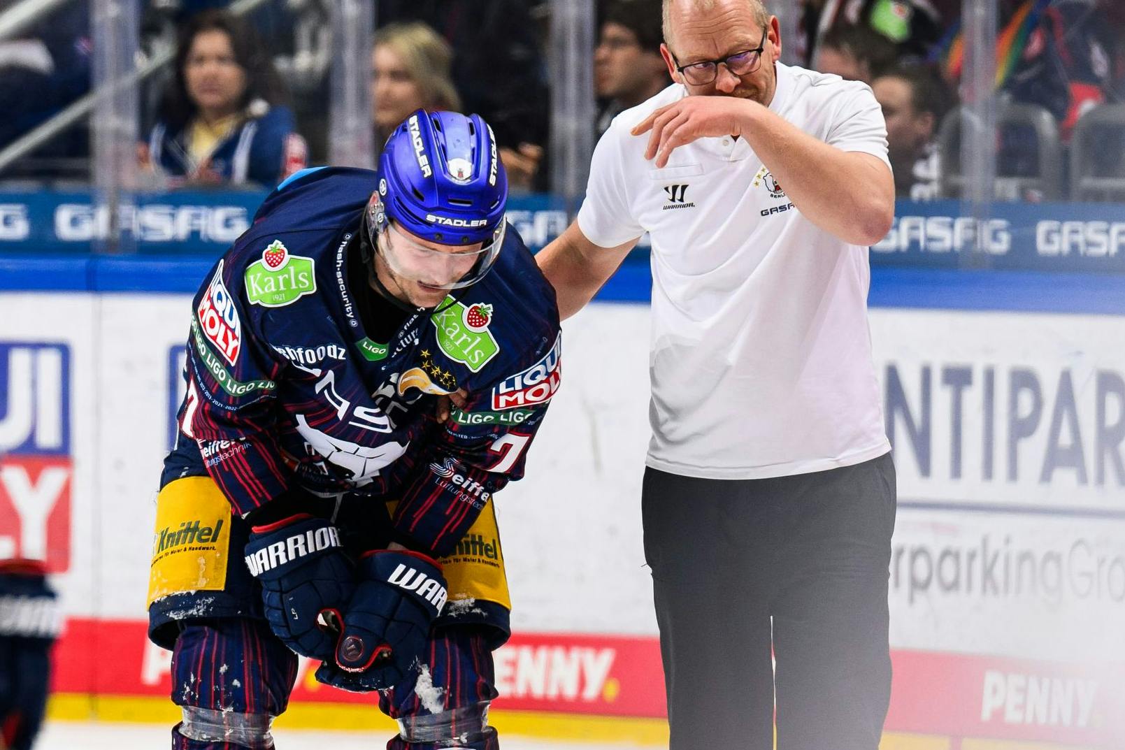 Eisbären-Kapitän Frank Hördler (l.) verlässt vor Schluss gegen Ingolstadt das Eis mit Unterstützung von EHC-Physio Thomas Wöhrl. 