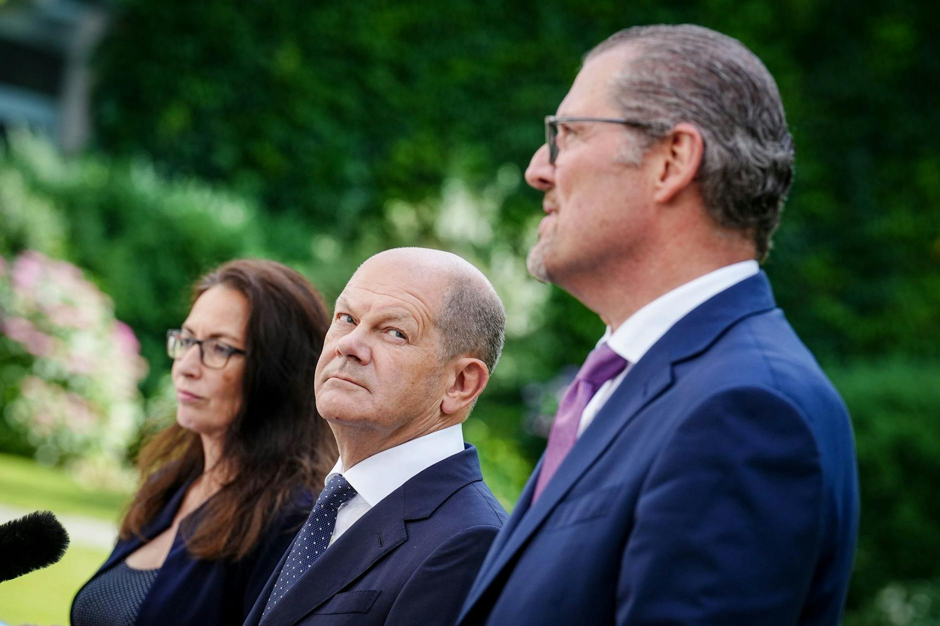 Kanzler Olaf Scholz (M), DGB-Chefin Yasmin Fahimi und Arbeitgeberpräsident Rainer Dulger.