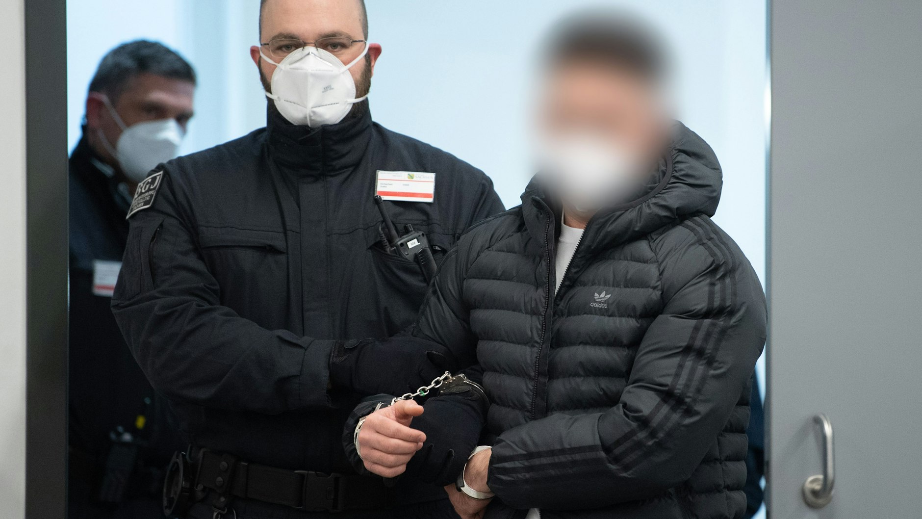 Ein angeklagtes Mitglied des Remmo-Clans wird im Prozess um den Juwelenraub im Grünen Gewölbe in den Gerichtssaal geführt.