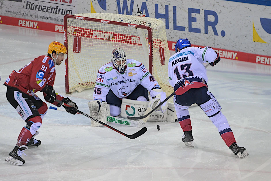 Peter Regin von den Eisbären Berlin (13) hilft Torwart Tobias Ancicka gegen Miha Verlic von den Fischtown Pinguins Bremerhaven.
