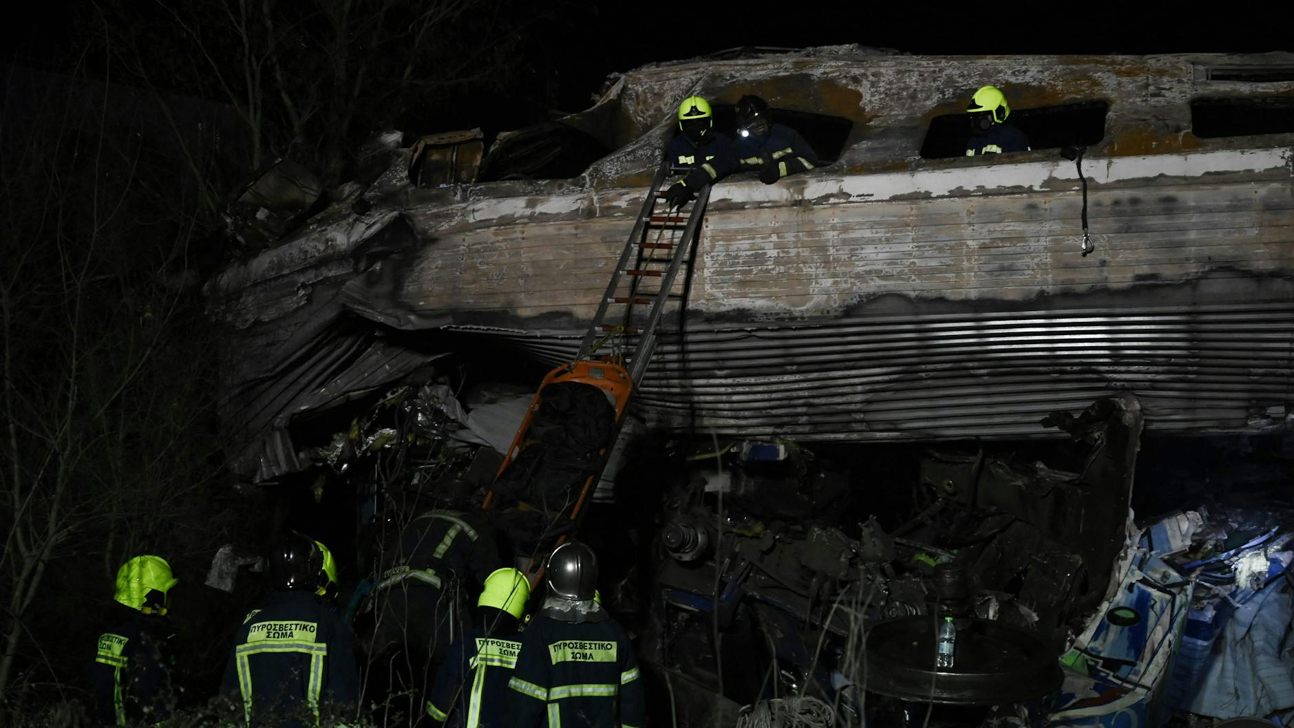 Rettungskräfte tragen nach einem Zugunglück in Griechenland in der Nähe von Larisa eine Leiche aus den Trümmern.