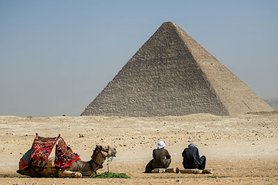 Ägypten, Gizeh: Ein Kamel und seine Reiter vor der Großen Pyramide von Gizeh. Ein internationales Forschungsteam hat in der berühmten Cheops-Pyramide eine bisher unbekannte Kammer nachgewiesen.