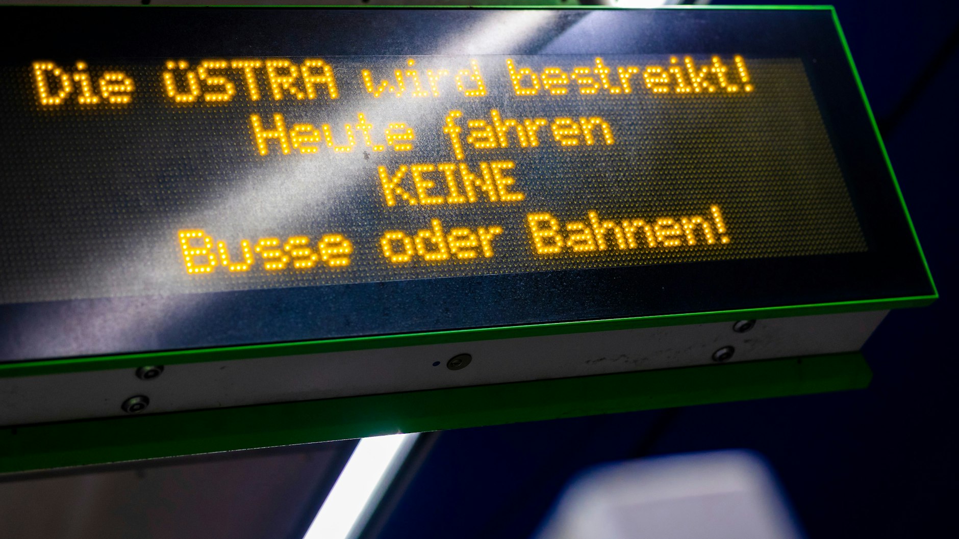 Auf einer Anzeigetafel an einer Stadtbahnhaltestelle  ist am Morgen der Schriftzug «Die Üstra wird bestreikt! Heute fahren keine Busse oder Bahnen» zu lesen. 