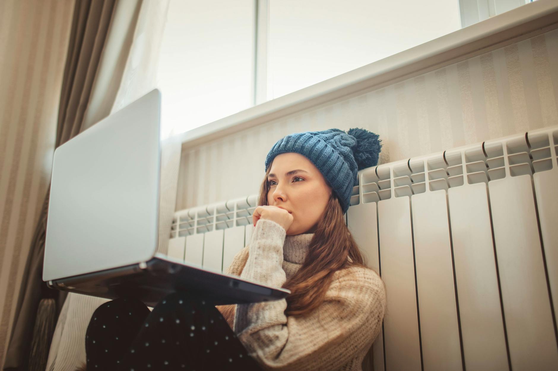 Eine Frau lehnt sich an die Heizung.