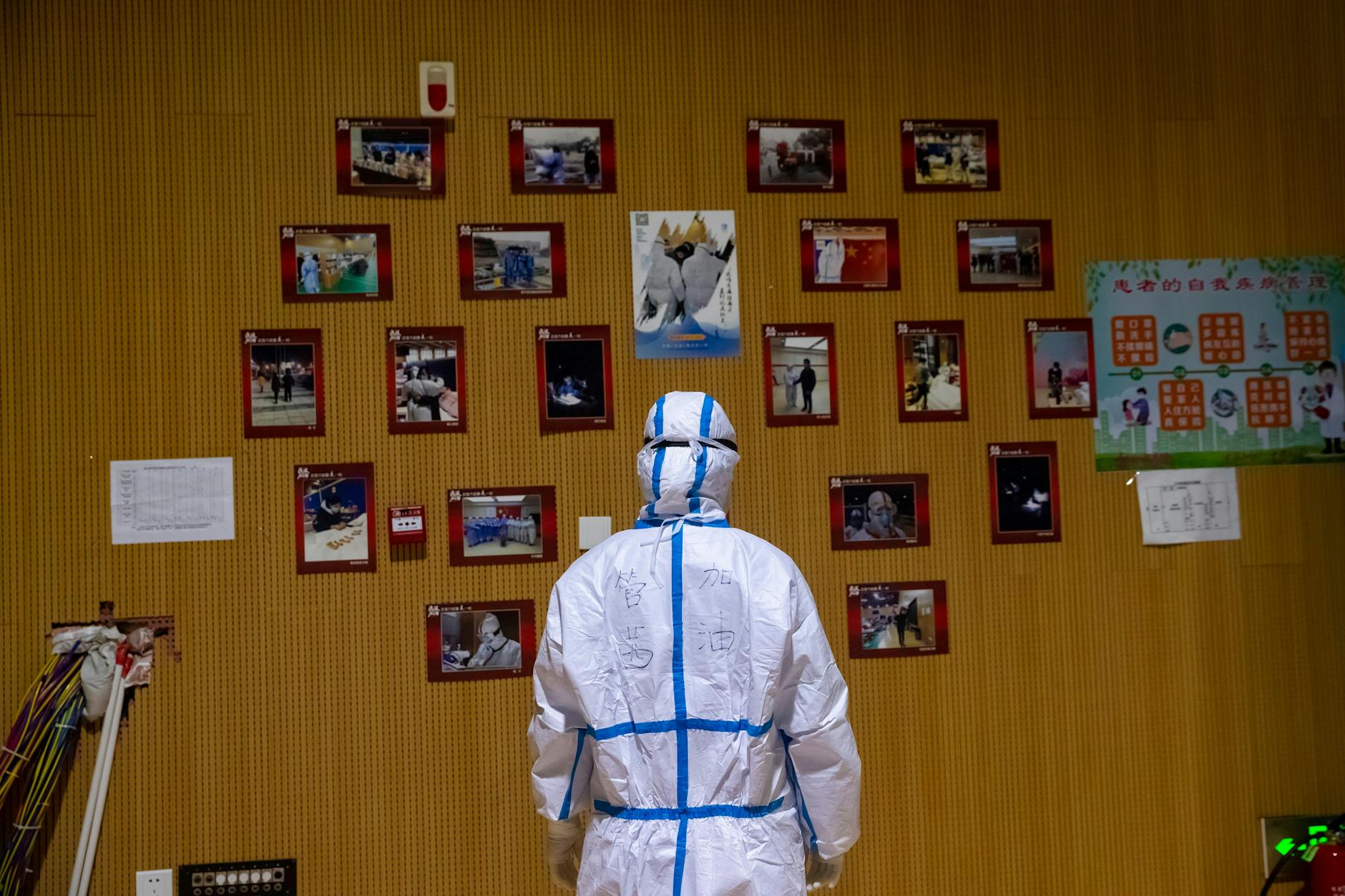 Wuhan: Ein chinesischer Mediziner betrachtet Fotos von Patienten und medizinischem Personal in einem provisorischen Krankenhaus in der Provinz Hubei.