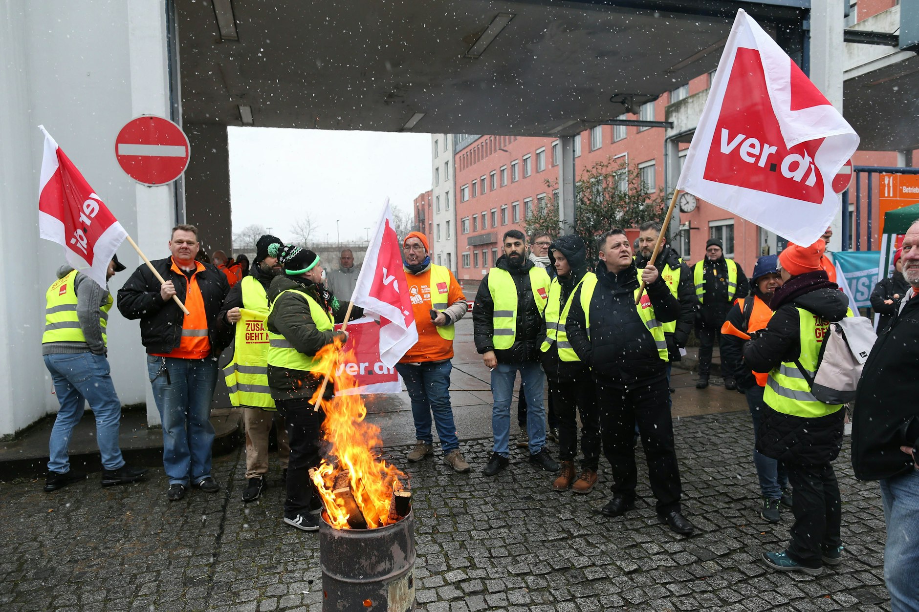 Es schneit, in einer Tonne lodert ein wärmendes Feuer: Mitarbeiter der Berliner Stadtreinigung streiken vor dem BSR-Hof in der Tempelhofer Ringbahnstraße.