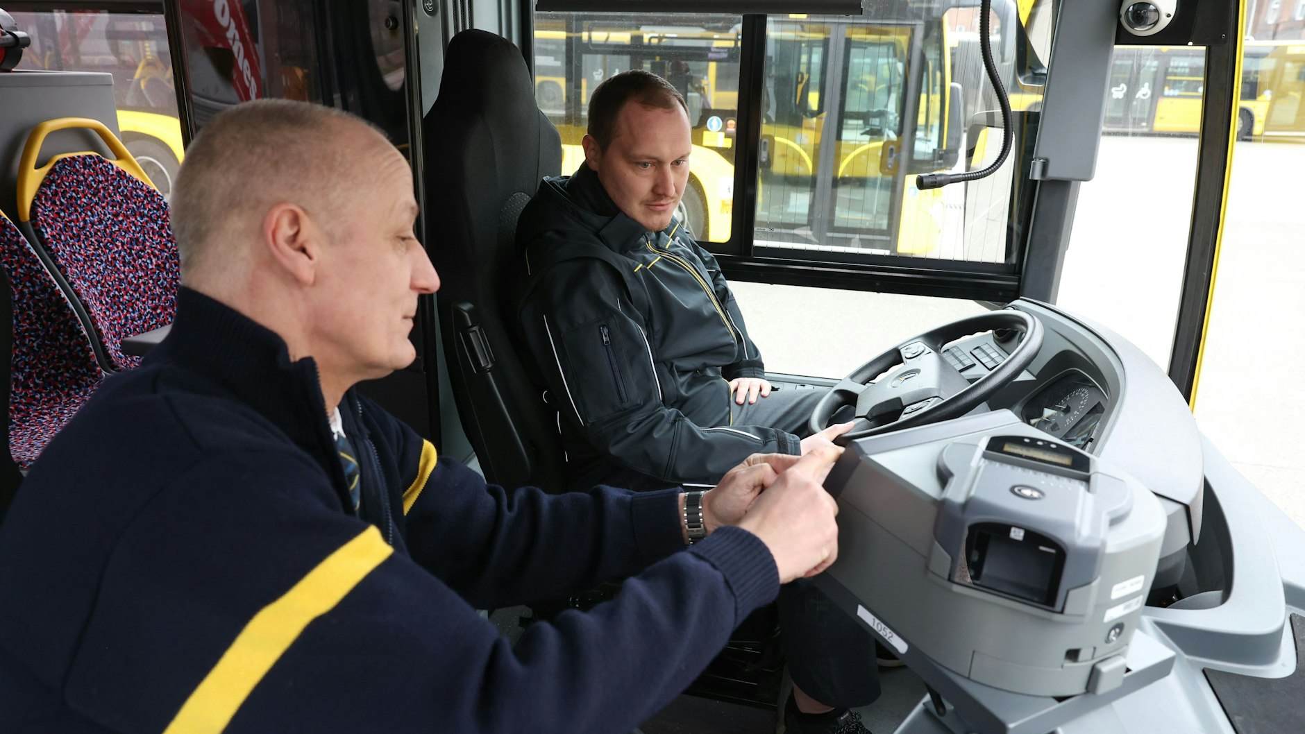 Der Ausbilder Tobias Kutta (li.) erklärt dem Fahrschüler Maik Flemming in der BVG-Fahrschule die Funktionsweise eines Fahrschulbusses.