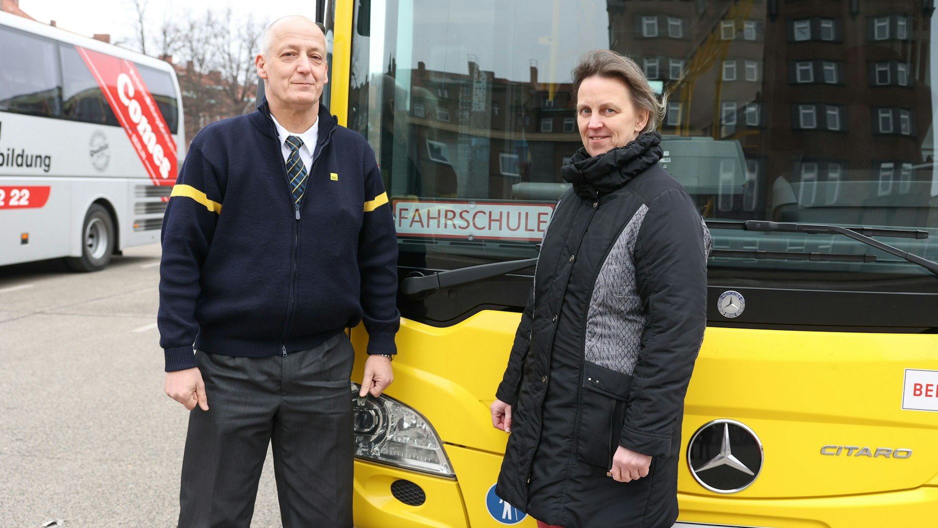 Tobias Kutta und Katrin Kern von der BVG-Fahrschule stehen vor einem Fahrschulbus auf dem BVG-Omnibusbetriebshof in der Müllerstraße.