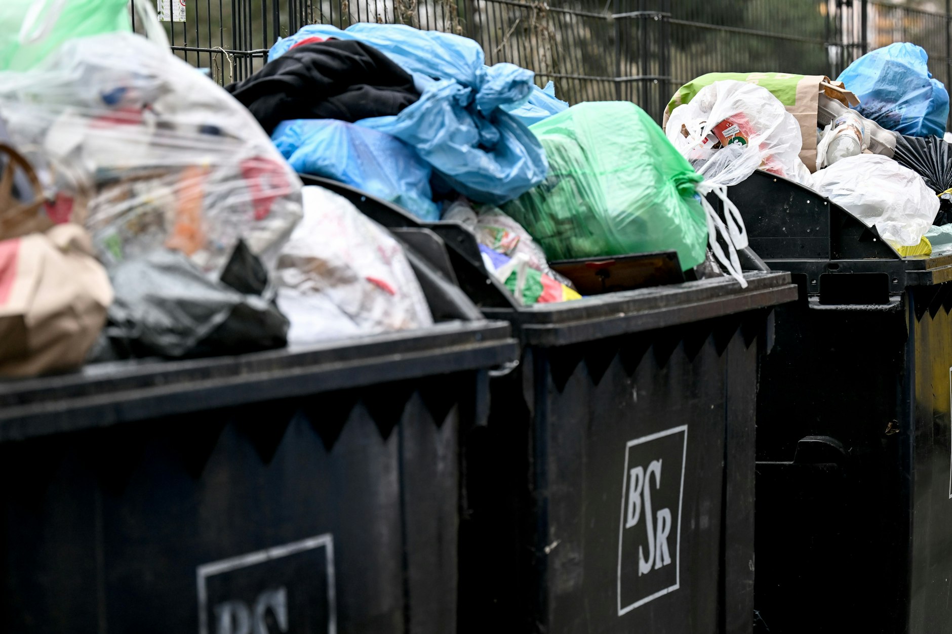 Überfüllte Mülltonnen stehen in einer Wohnsiedlung. Ab Donnerstag könnte es mit den Leerung in Berlin wieder losgehen.